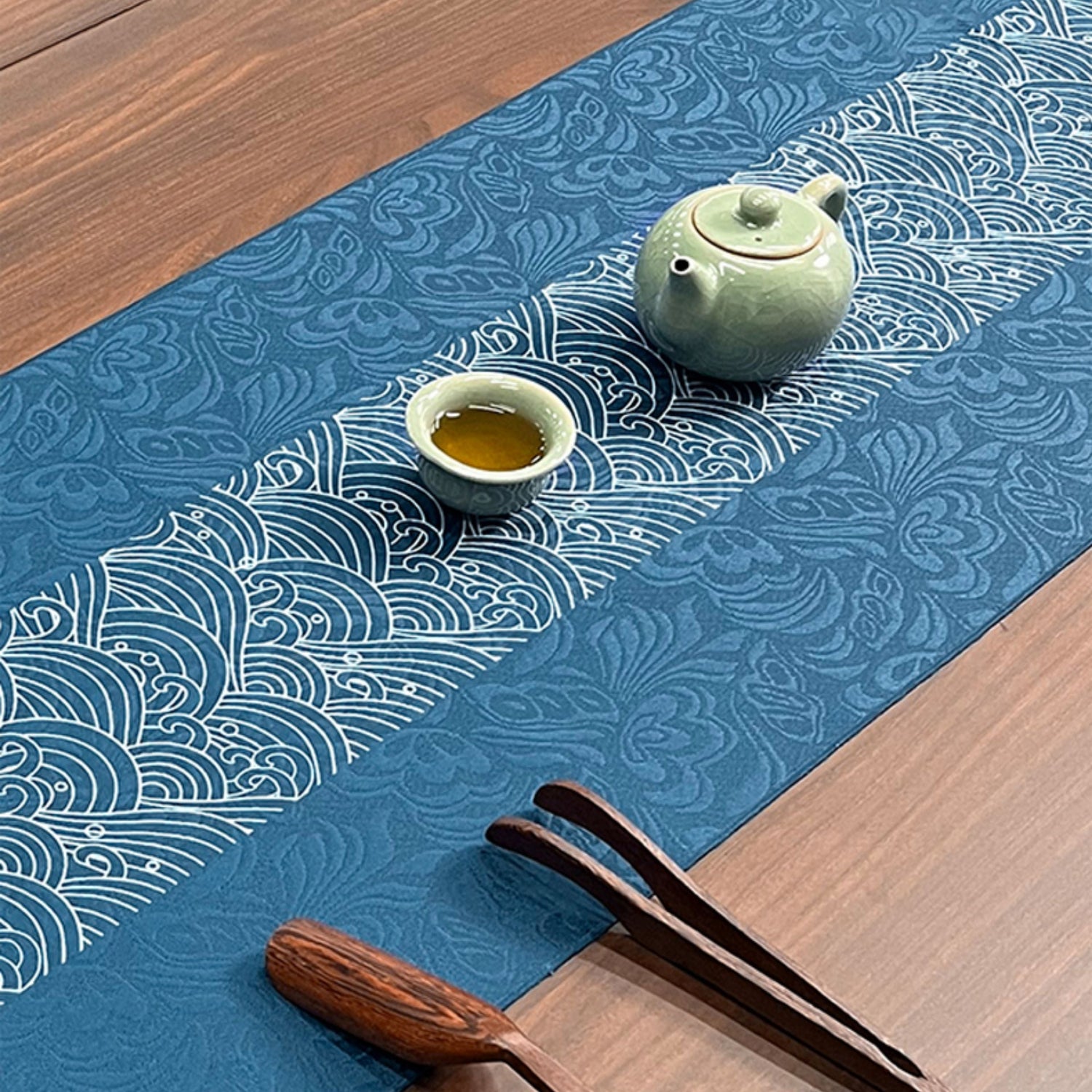 Tea set on a blue patterned table runner on a wooden surface