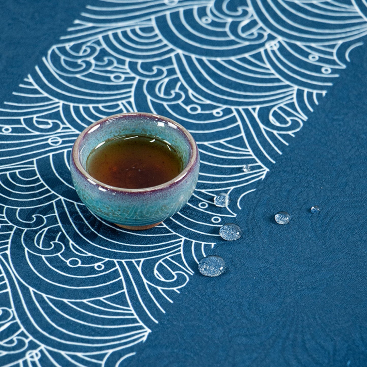 Tea cup on a blue patterned surface with Chinese text