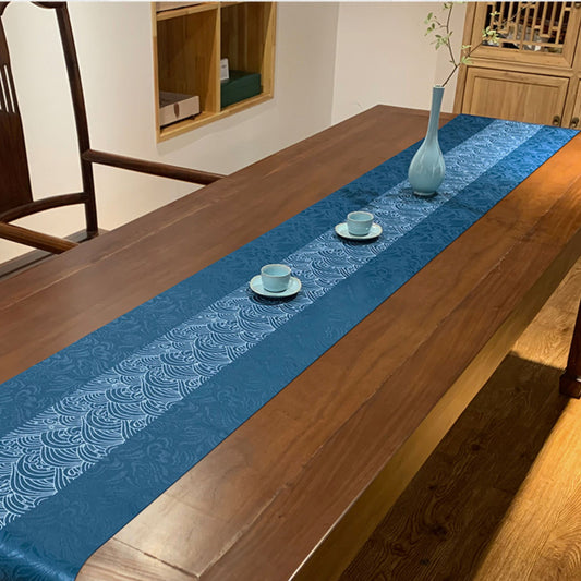 Blue table runner with white patterns on a wooden table in a room setting.